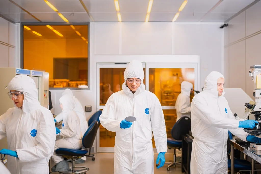 Researchers working with fabrication and microscopy equipment in the University of Houston Nanofabrication Facility cleanroom.